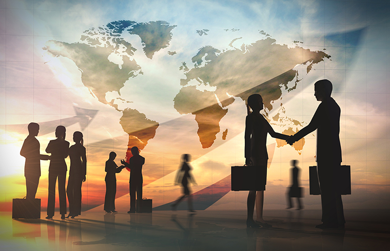 Silhouettes of business people networking with a world map in the background.