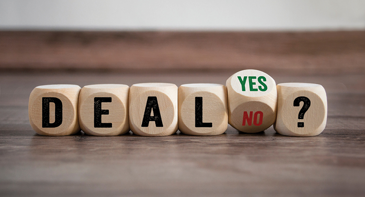 Wooden dice spelling out the word DEAL, with one die turned to YES/NO and a question mark.