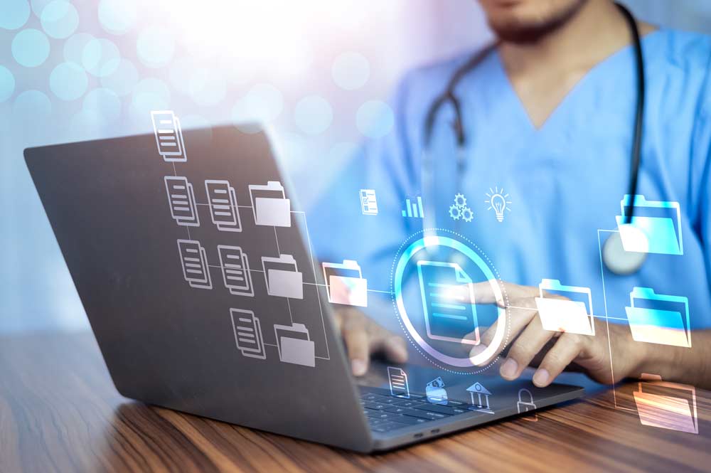 A person in scrubs working on a laptop with a digital overlay of document folder icons.