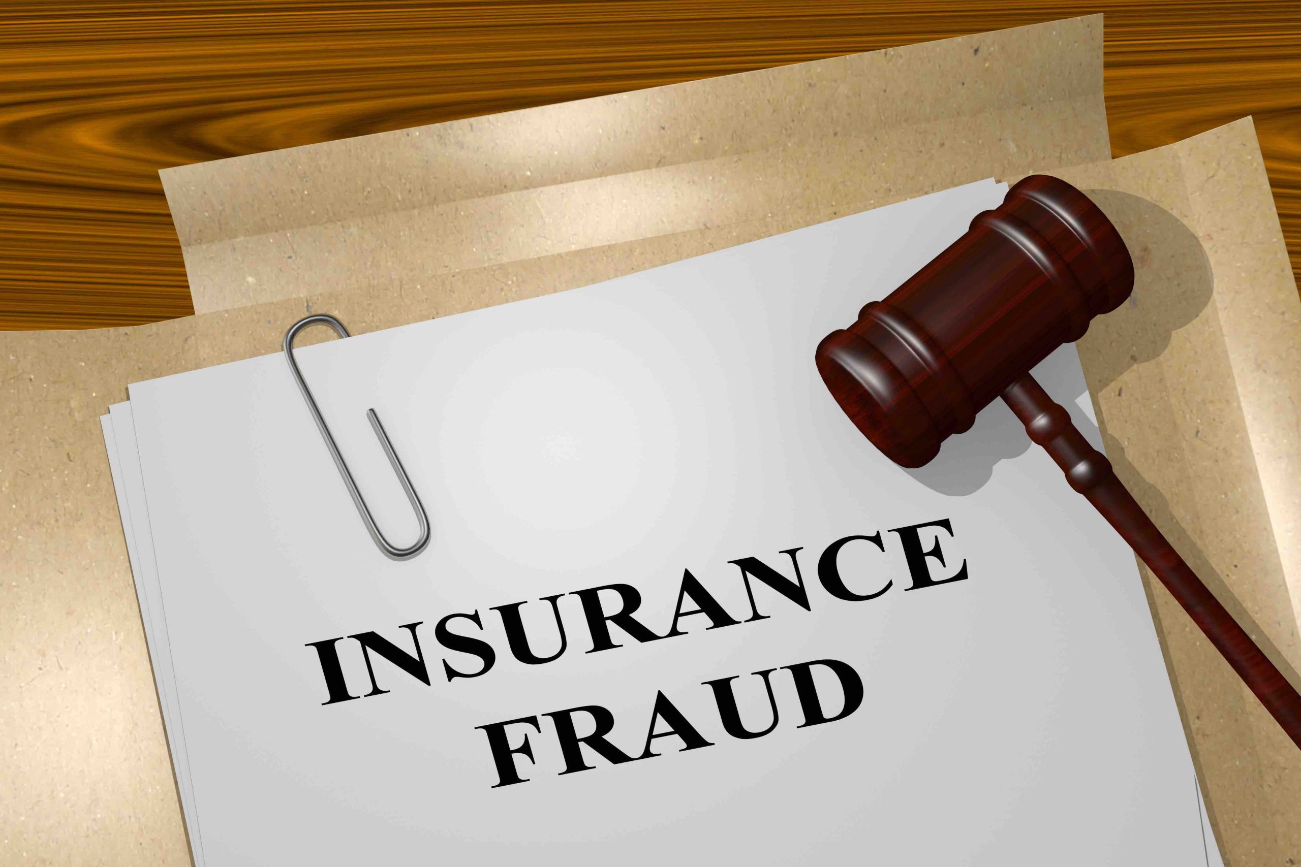 A document titled INSURANCE FRAUD with a judge's gavel resting on it.