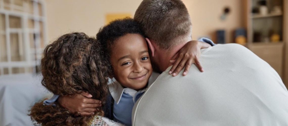 A happy, diverse family group hugging.