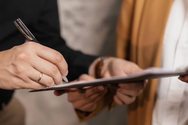 A close-up of a person signing a legal document.