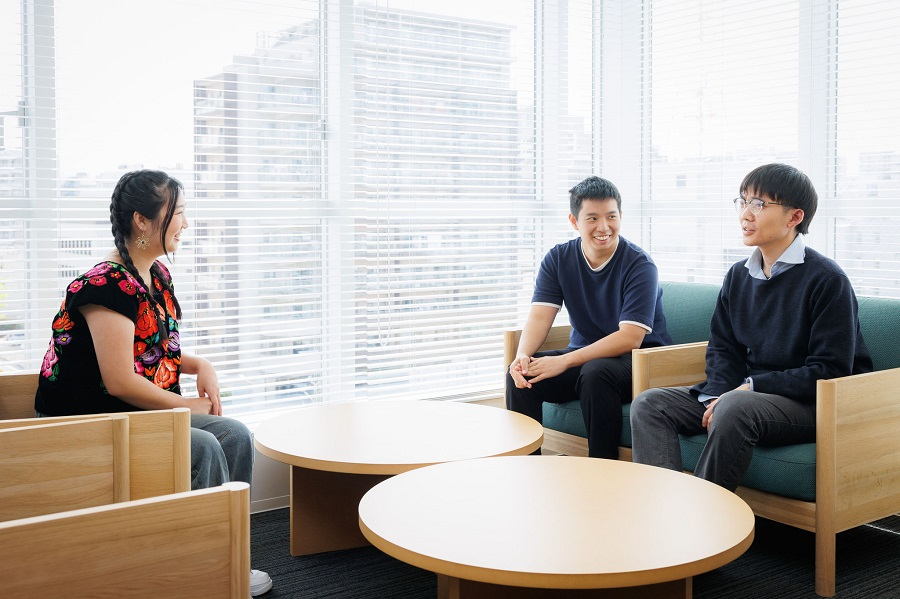 Three young adults having a pleasant conversation in a brightly lit room.
