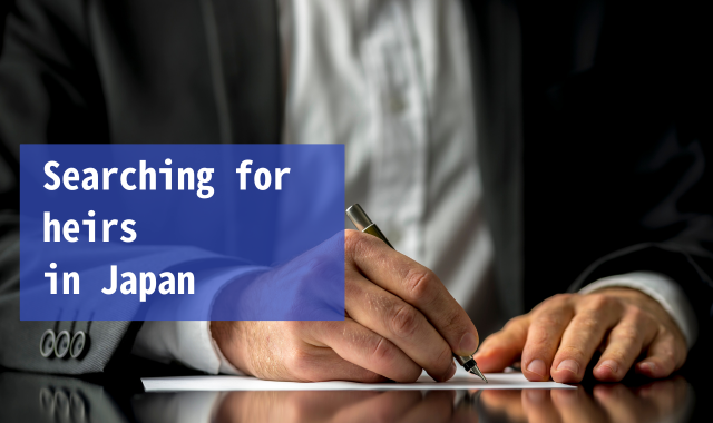 A person in a suit signing a document with a pen.