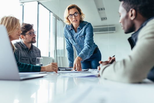 A team of professionals in a serious business meeting around a conference table.