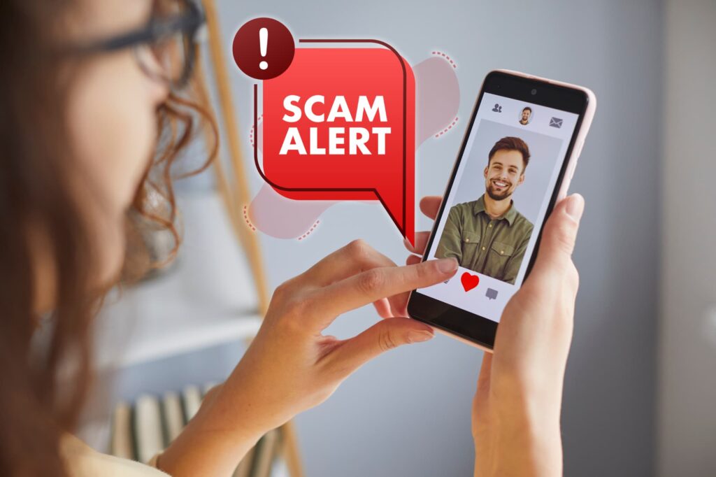 A person holding a phone with a dating profile on screen and a large 'SCAM ALERT' graphic.